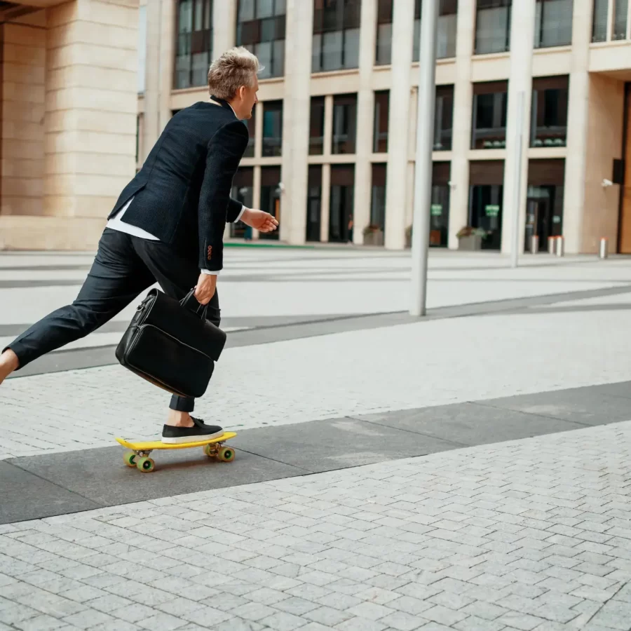 Un homme en tenu business sur un skateboard
